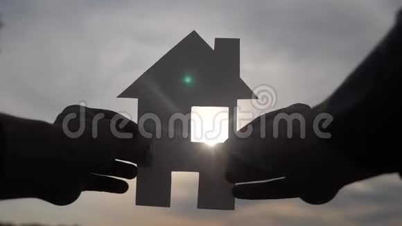 幸福生活方式家庭住宅建设理念一个人手里拿着一个纸房手里拿着夕阳的剪影视频的预览图