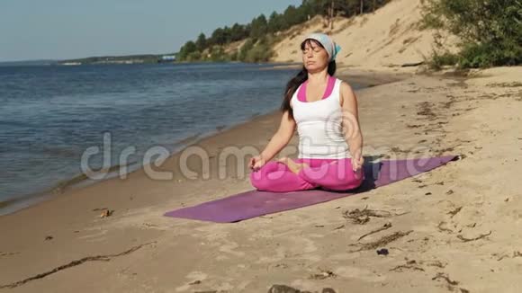 退休老女人在海滩上做瑜伽超级慢动作视频的预览图