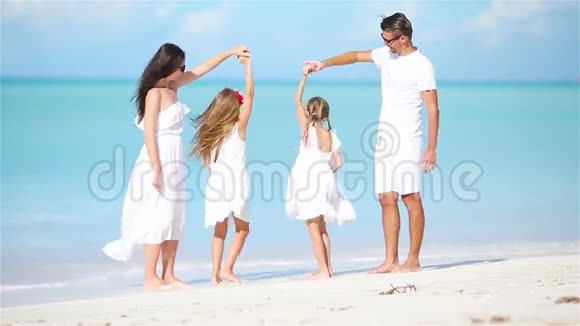 年轻的家庭在白色的热带加勒比海海滩上玩得开心视频的预览图