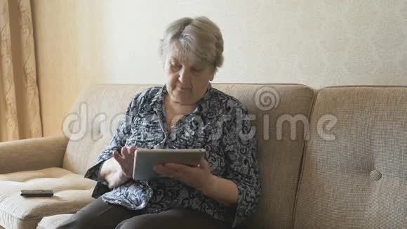 坐在沙发上的老女人在说手机视频的预览图