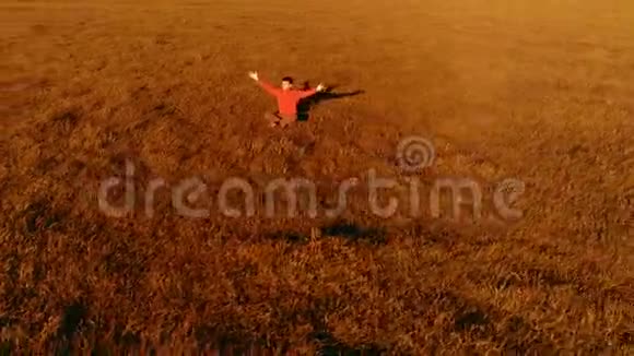 低空径向飞行超过运动瑜伽男子在完美的绿草在山上日落视频的预览图