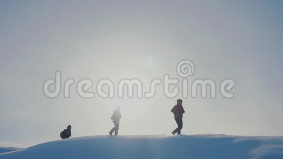 团队合作男子登山徒步旅行生活方式山顶山石峰群队阳光剪影雪脚视频的预览图