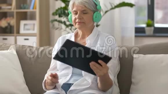 戴耳机听音乐的高级女性视频的预览图