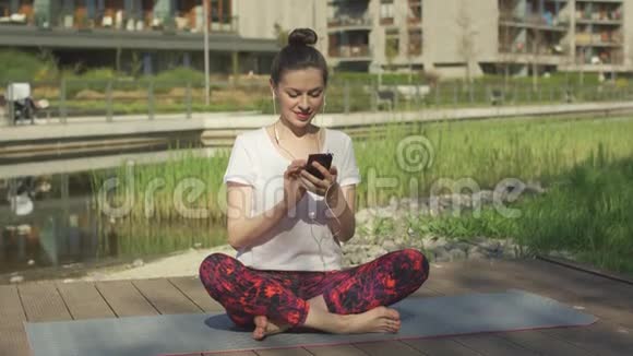 戴着智能手机耳机的年轻女人视频的预览图