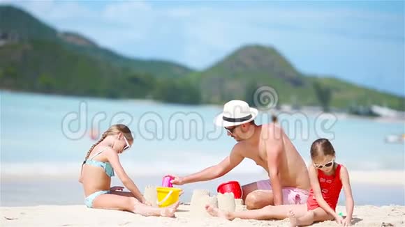 家庭在热带白色海滩制作沙堡视频的预览图