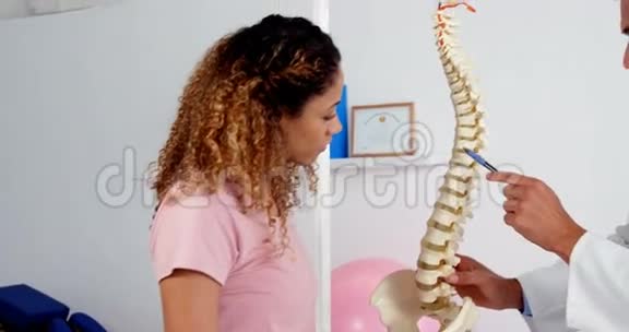 物理治疗师向病人解释脊柱模型视频的预览图