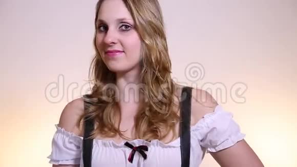 穿着传统的白色背景巴伐利亚服装的年轻金发女子视频的预览图