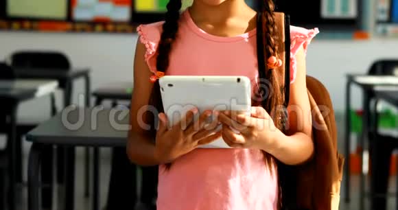4k教室里有一个女生拿着数字平板电脑视频的预览图