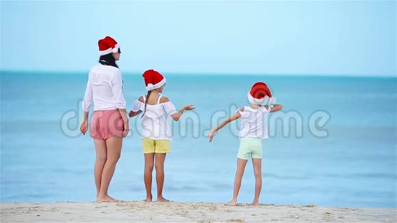 圣诞节假期一家人在白色海滩戴圣诞帽视频的预览图