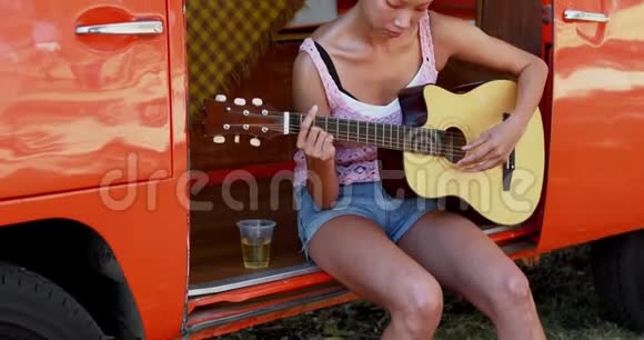 女在露营车4k里弹吉他视频的预览图