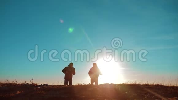 团队合作两名游客徒步旅行男人和狗带着背包在日落时去徒步旅行慢动作视频旅行和徒步旅行视频的预览图