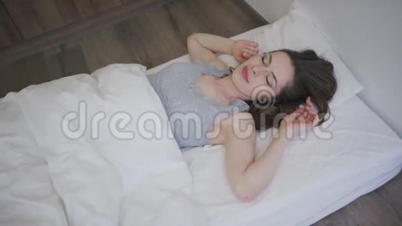 迷人的女人躺在床上微笑视频的预览图