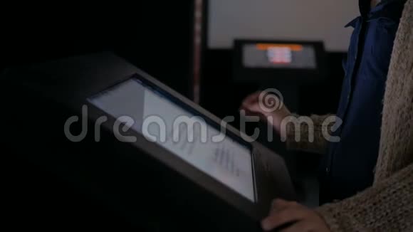 女士使用交互式触摸屏显示视频的预览图