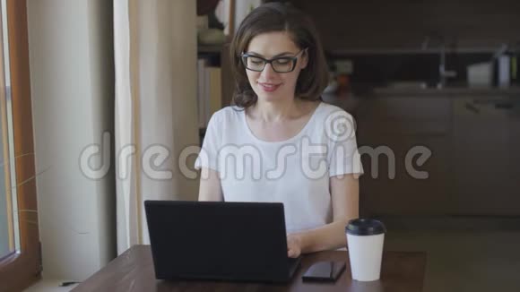 有魅力的女人在家里用笔记本电脑视频的预览图