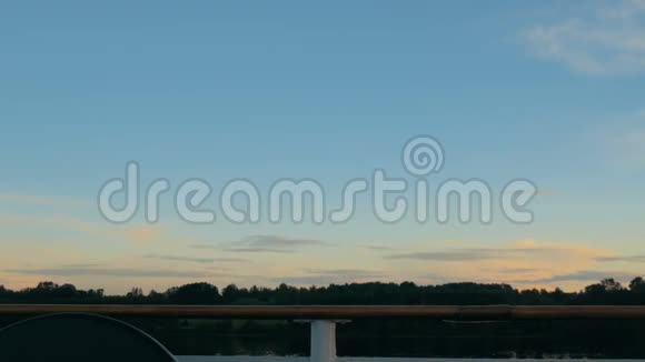日落后游船甲板上欣赏风景的女人视频的预览图