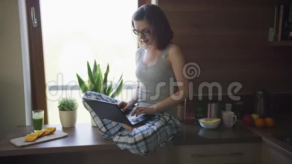 有魅力的女人坐在桌子上用笔记本电脑视频的预览图