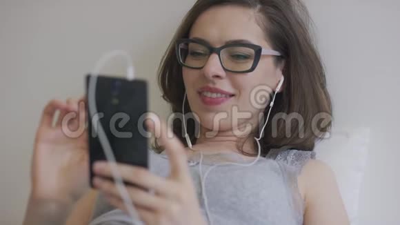 智能手机听音乐的年轻女性视频的预览图