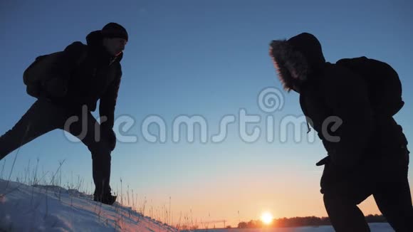 团队合作商务旅行剪影概念两个徒步旅行者冬季雪地旅游者攀登到生活方式的顶端视频的预览图