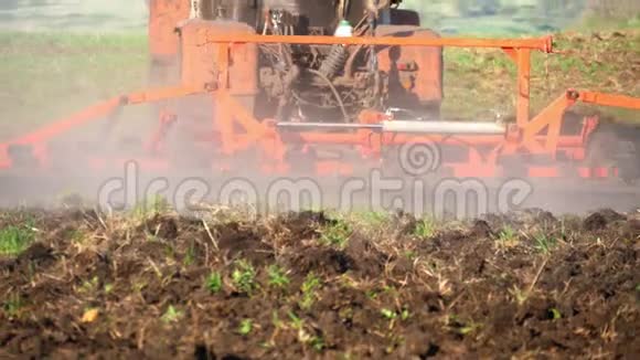 农用拖拉机播种栽培田拖拉机在日落时在田里工作视频的预览图