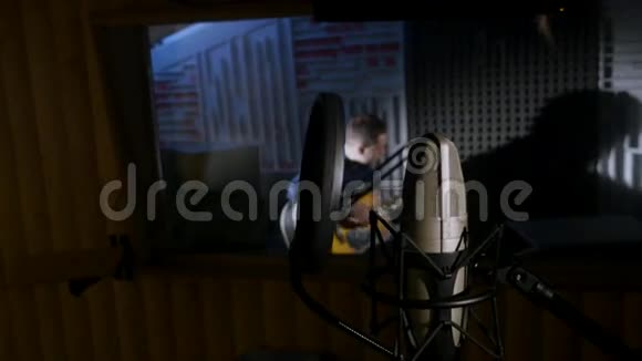 麦克风在一个位于音乐工作室录音亭低键光下的立场视频的预览图