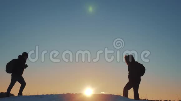 团队合作商业生活方式旅行剪影概念两个徒步旅行者冬季雪地旅行者登山者爬到山顶视频的预览图