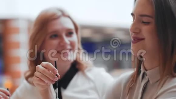 两个年轻的女人坐在咖啡馆里聊天喝咖啡视频的预览图