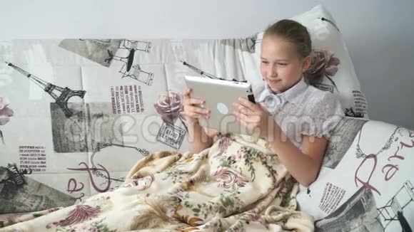 躺在床上看数字平板电脑的孩子视频的预览图
