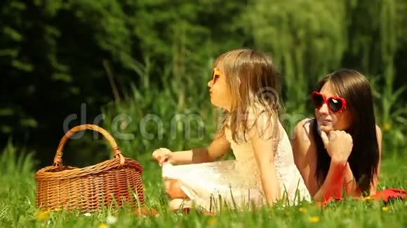 野餐母亲和女儿在草地上放松视频的预览图