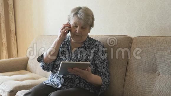 坐在沙发上的老女人在说手机视频的预览图