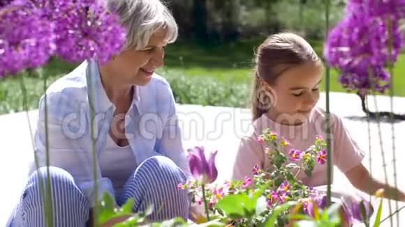 祖母和女孩在花园里种花视频的预览图