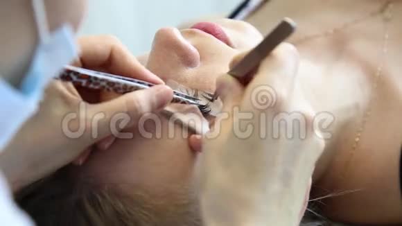 漂亮的年轻女人睫毛延伸长睫毛的女人眼美容师为年轻人士提供睫毛延伸服务视频的预览图