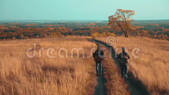 人们在大自然中旅行秋天的冒险慢动作视频两个徒步旅行者户外背包徒步旅行视频的预览图