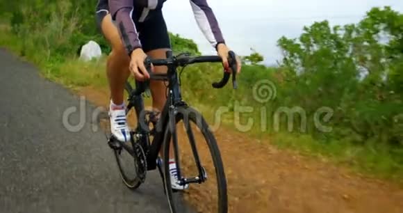 骑自行车的女性在乡村公路上骑自行车视频的预览图