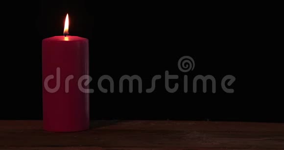 桌子上燃烧着红色的圣诞蜡烛视频的预览图