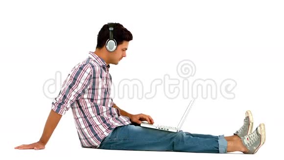 带耳机的人坐在地上用笔记本电脑视频的预览图