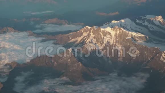 在夏季飞越欧洲阿尔卑斯山冰川的景观从飞机窗口可以看到空中景色视频的预览图