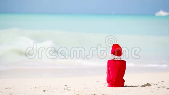 圣诞假期在白色海滩戴圣诞帽的可爱女孩视频的预览图
