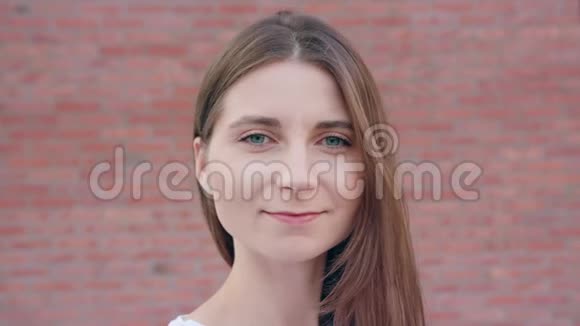 年轻女士在砖墙背景下微笑视频的预览图