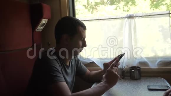 火车车厢上的人听音乐用信使社交媒体智能手机写信息视频的预览图
