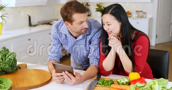 家庭厨房用数码平板电脑的情侣视频的预览图
