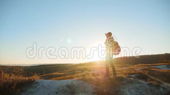 男子剪影漫步旅游徒步探险登山者日落爬山慢动作视频徒步旅行者的阳光视频的预览图