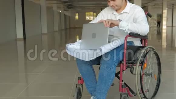 一位坐在轮椅上的残疾商人在窗户上画着一张大纸通过电话讨论工作视频的预览图