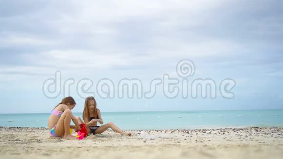 两个孩子在制作沙堡和在热带海滩玩耍视频的预览图