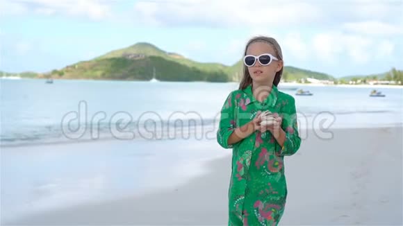加勒比海度假期间海滩上戴帽子的可爱小女孩视频的预览图