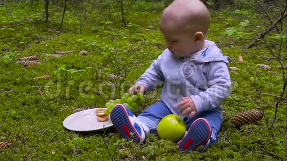 婴儿是婴儿坐在森林里吃大苹果视频的预览图