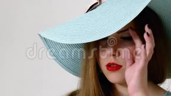 戴着大帽子摆姿势的年轻女人视频的预览图