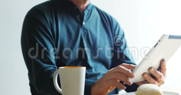 男人在喝4k咖啡时使用数码平板电脑视频的预览图