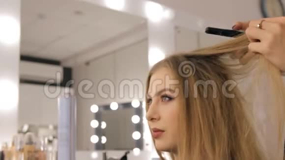 专业的化妆师和发型师为一个美丽的年轻女孩创造了一个美丽的形象视频的预览图
