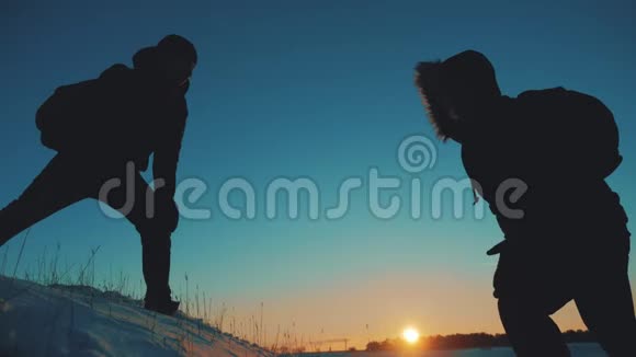 团队合作商务旅行剪影概念两个徒步旅行者冬季雪游客登山者攀登到最顶级的生活方式视频的预览图