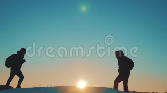 团队合作商务旅行生活方式剪影概念两个徒步旅行者冬季雪地旅行者登山者爬到山顶视频的预览图